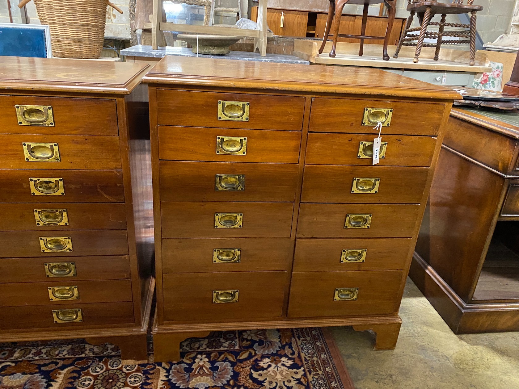A near pair of mahogany and walnut military style chests of drawers, larger width 82cm, depth 54cm, height 85cm